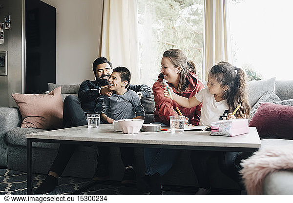 Glückliche Familie  die ihre Freizeit im Wohnzimmer verbringt