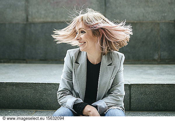 Glückliche Frau bewegt ihr rosa Haar