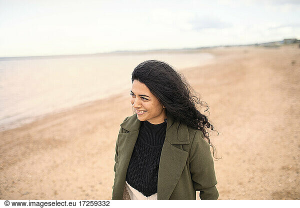 Glückliche Frau im Winter Mantel auf Winter Ozean Strand