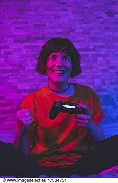 Glückliche Frau mit Spiel-Controller spielen Videospiel zu Hause