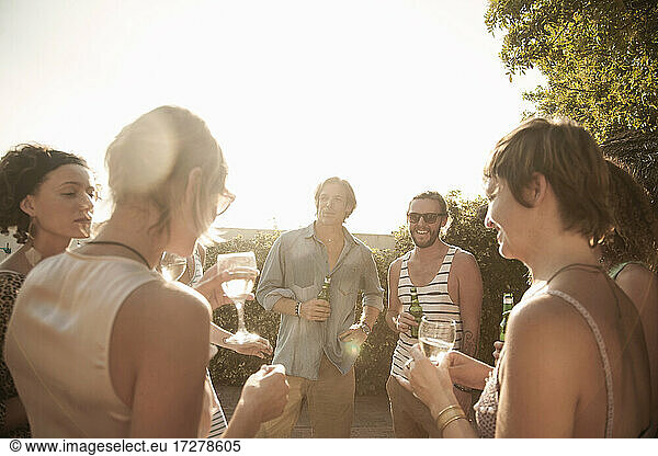 Glückliche Freunde genießen den Sommer und trinken Alkohol gegen den Himmel
