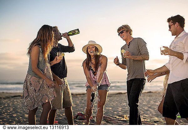 Glückliche Freunde genießen Drinks am Strand