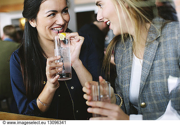 Glückliche Freunde unterhalten sich bei einem Drink im Restaurant