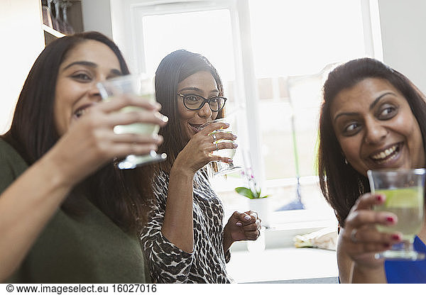 Glückliche indische Frauen trinken in der Küche