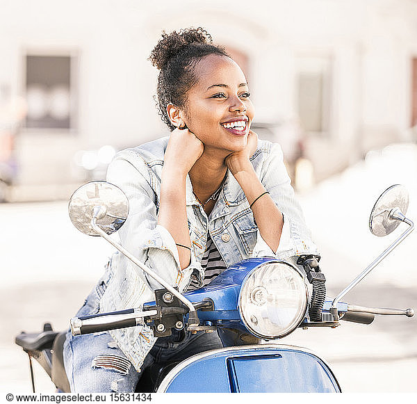 Glückliche junge Frau mit Motorroller in der Stadt  Lissabon  Portugal