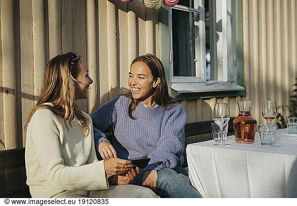 Glückliche junge Frauen  die sich während einer Dinnerparty im Café unterhalten