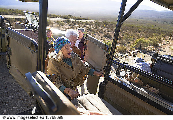 Glückliche ältere Frau beim Einsteigen in einen Safari-Geländewagen