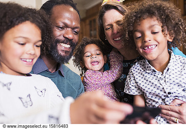 Glückliche multiethnische Familie mit Smartphone