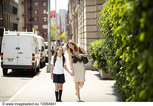 Glückliche Mutter bringt Tochter zur Schule