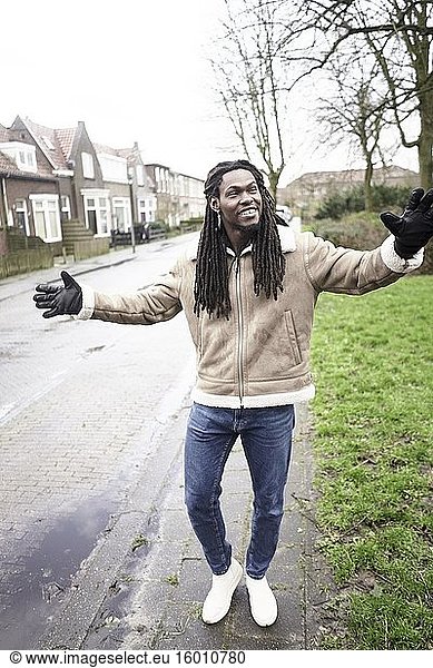 Glücklicher afrikanischer Mann  der sich in einem Wohnviertel in Leeuwarden  Friesland  Niederlande  Europa  frei fühlt