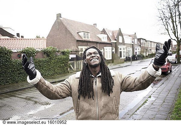 Glücklicher afrikanischer Mann genießt die Freiheit in einem Wohnviertel in Leeuwarden  Friesland  Niederlande  Europa