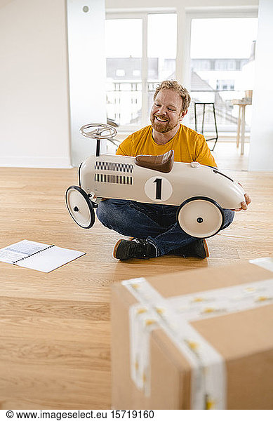 Glücklicher Mann hält Spielzeugauto