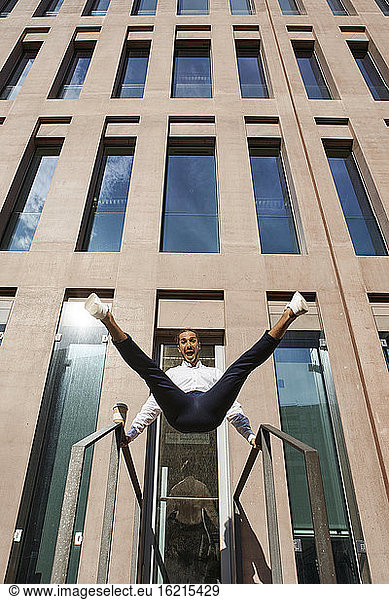 Glücklicher Unternehmer tanzt gegen Gebäude