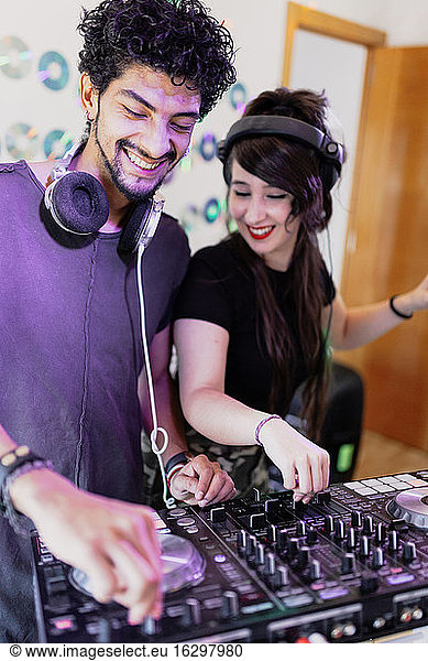 Glückliches DJ-Paar  das im Aufnahmestudio gemeinsam Ton mischt
