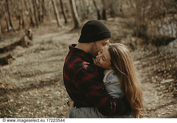 Glückliches erwachsenes Paar  das sich im Wald umarmt