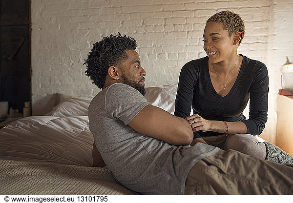 Glückliches junges Paar sieht sich im Schlafzimmer an