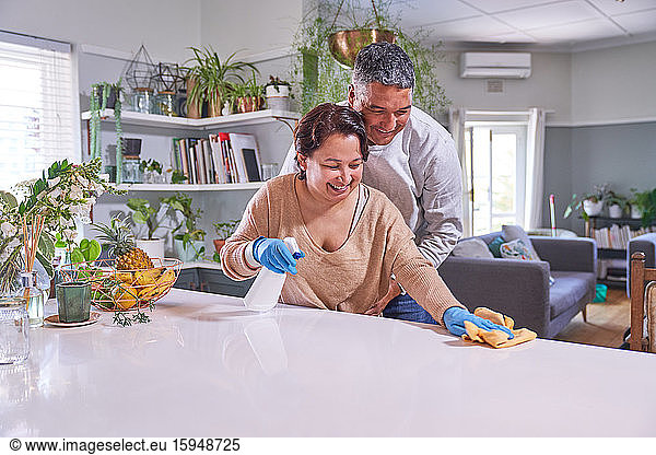 Glückliches  liebevolles  reifes Paar putzt Kücheninsel