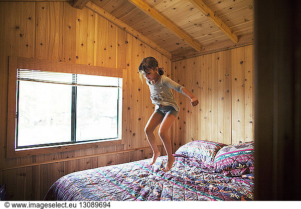 Glückliches Mädchen springt auf Bett