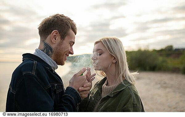 Glückliches Paar beim Ausruhen mit Marihuana-Joint