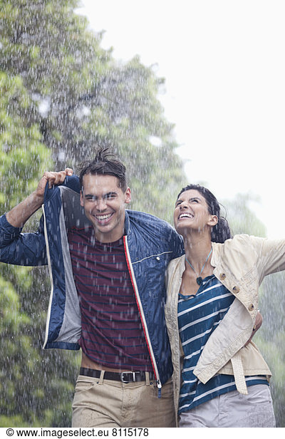 Glückliches Paar  das im Regen läuft