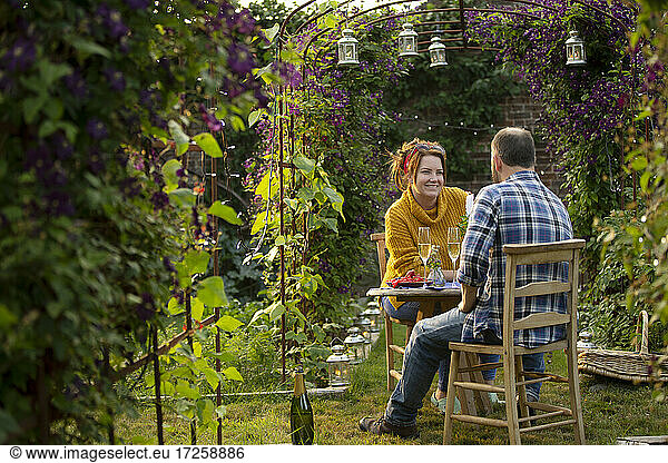 Glückliches Paar genießt Champagner im idyllischen Sommergarten
