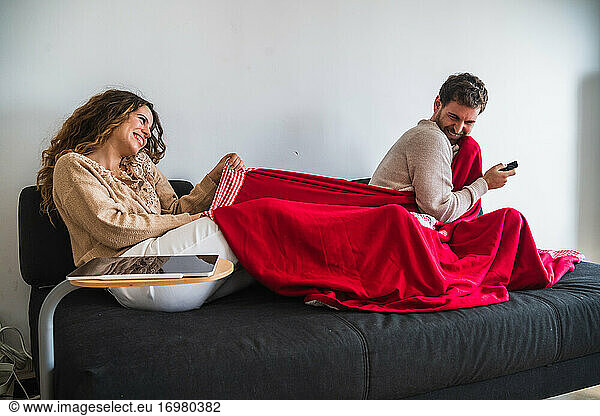 Glückliches Paar kämpft um Decke