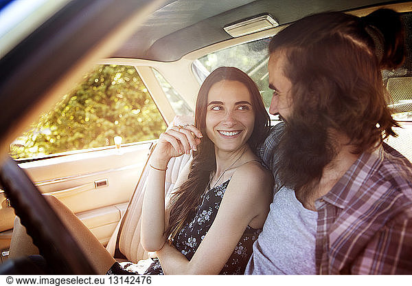 Glückliches Paar sieht sich an  während es im Pick-up sitzt