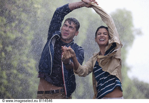 Glückliches Paar tanzt im Regen