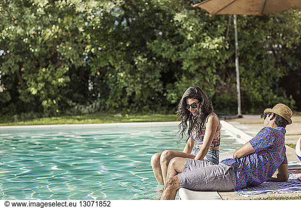 Glückliches Paar unterhält sich am Pool