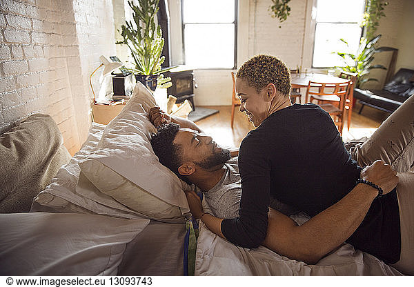 Glückliches romantisches Paar  das sich zu Hause im Bett betrachtet