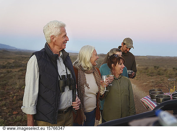 Glückliches Seniorenpaar auf Safari trinkt Champagner