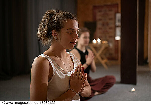 Glad female meditating during yoga session