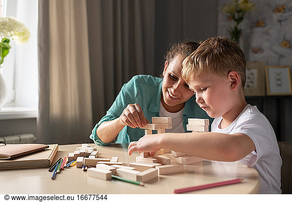 Glad woman and boy playing together