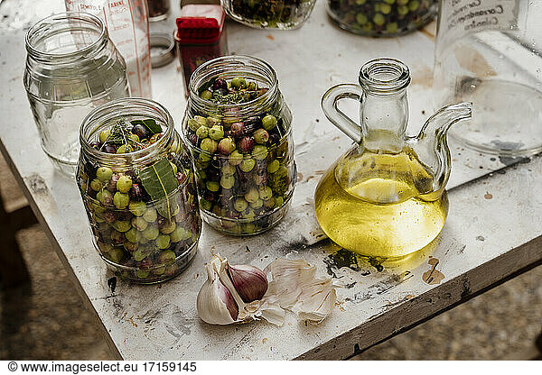 Glasgefäße mit Oliven und Knoblauch auf dem Tisch