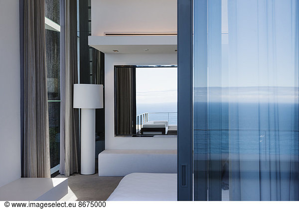 Glass door and windows of modern house overlooking ocean