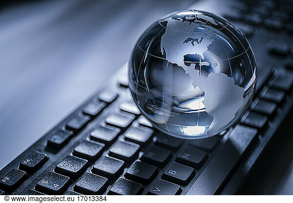 Glass globe on computer keyboard