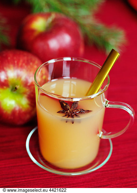 Glass of apple juice with two apples