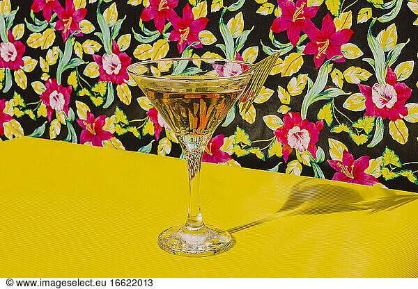 Glass of Cocktail liquor kept on yellow table in studio