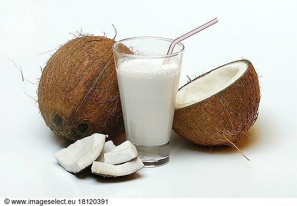 Glass of coconut milk  halved coconut  drinking straw  coconut milk  coconut pieces