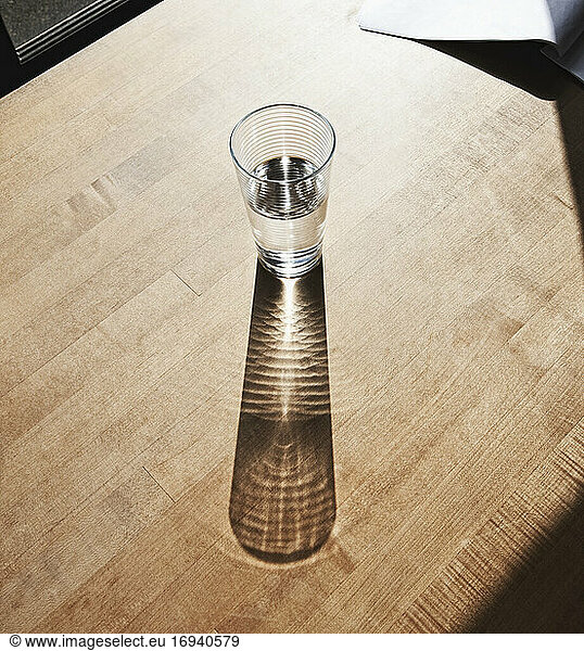 Glass of drinking water on wooden surface.