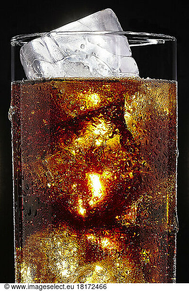 Glass of Soda with Ice Cubes on Black Background