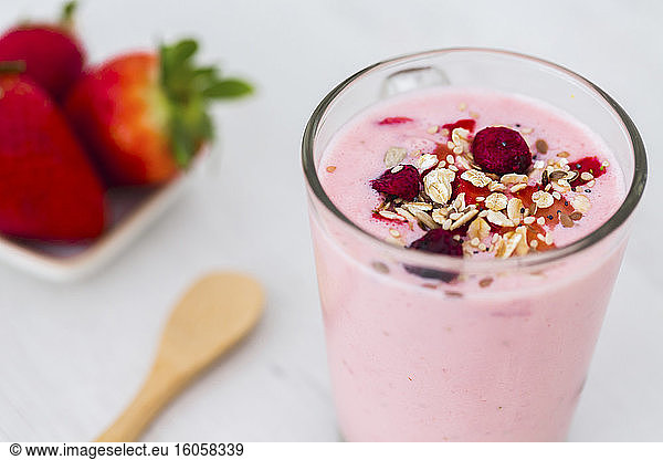 Glass of strawberry milkshake with cereals