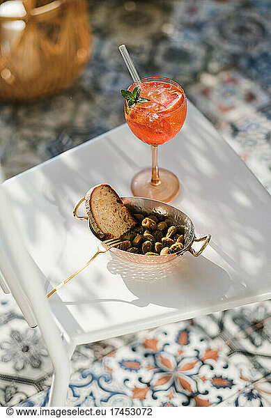 Glass of summer spritz cocktail and grilled Mediterranean olives