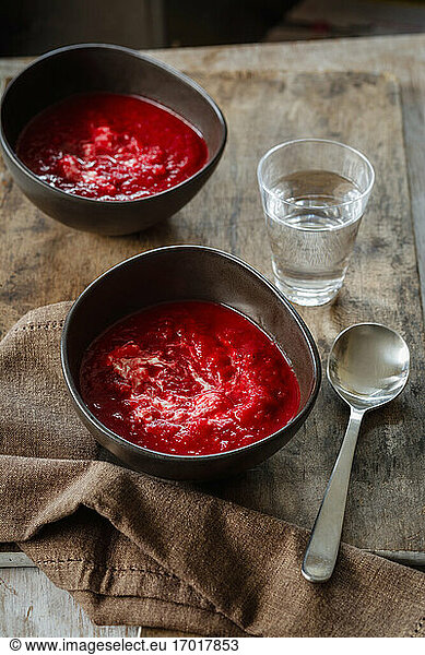 Glass of water and two bowls of beet soup