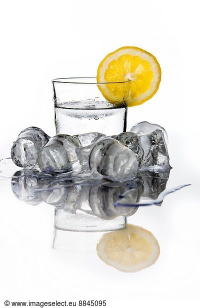 Glass of water with a lemon slice an ice cubes.