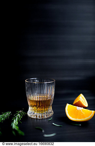 Glass with whiskey and orange.