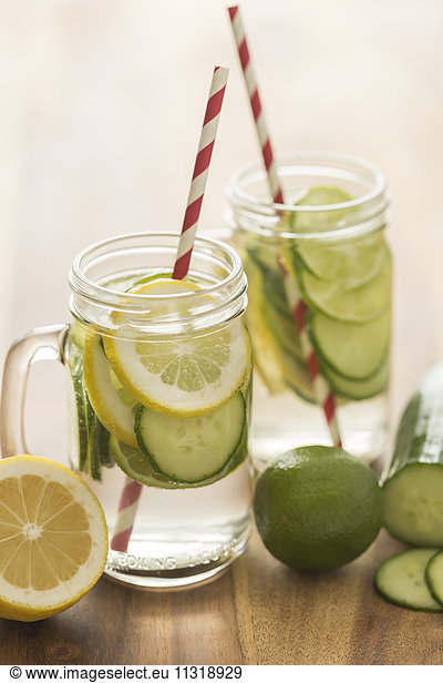 Glasses of infused water with lime  lemon  cucumber and ice cubes