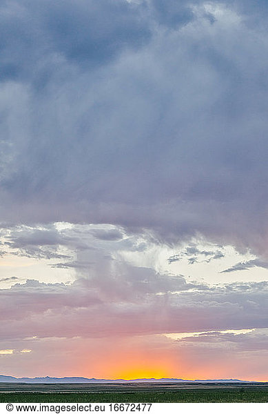 Glowing sunset touching horizon line over field in Meadow  Utah.