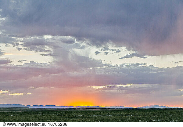 Glowing sunset touching horizon line over field in Meadow  Utah.