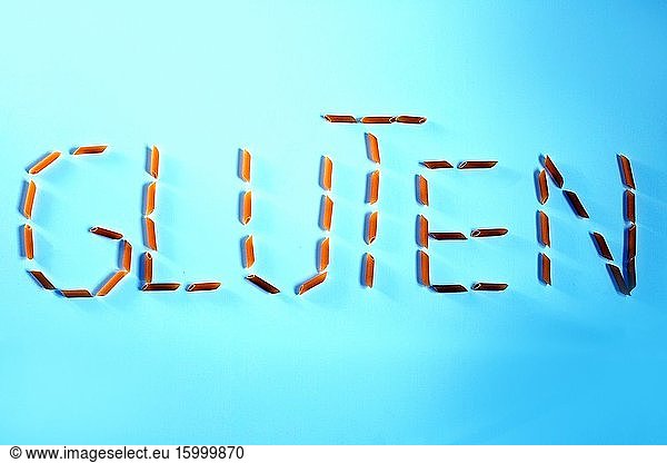 Gluten free word made with pasta penne isolated on blue background healthy.